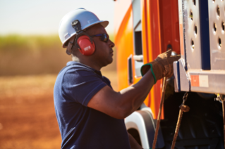 Man with helmet and ear protection securing cargo