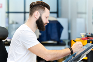Man with beard in white t-shirt working on drawing pad
