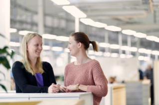 Two persons talking to each other in office area