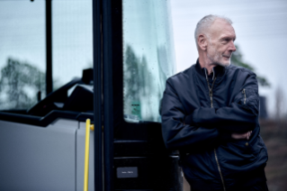 Man standing in front of truck looking into the camera