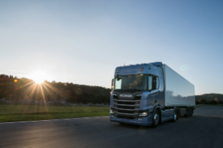 Truck driving on road in sunset