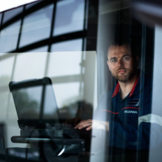 Service technician inside truck, seen from outside through the windscreen