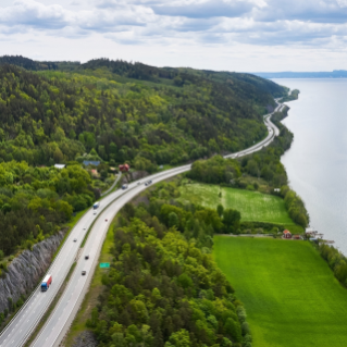 Road in green surroundins next to water