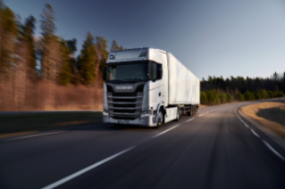 Truck driving on road in sunset