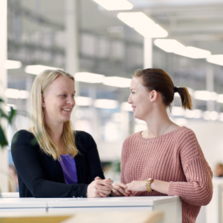 Two persons talking to each other in office area