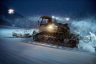 Snow groomer at night
