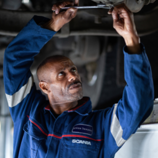 Male service technician working below a vehicle
